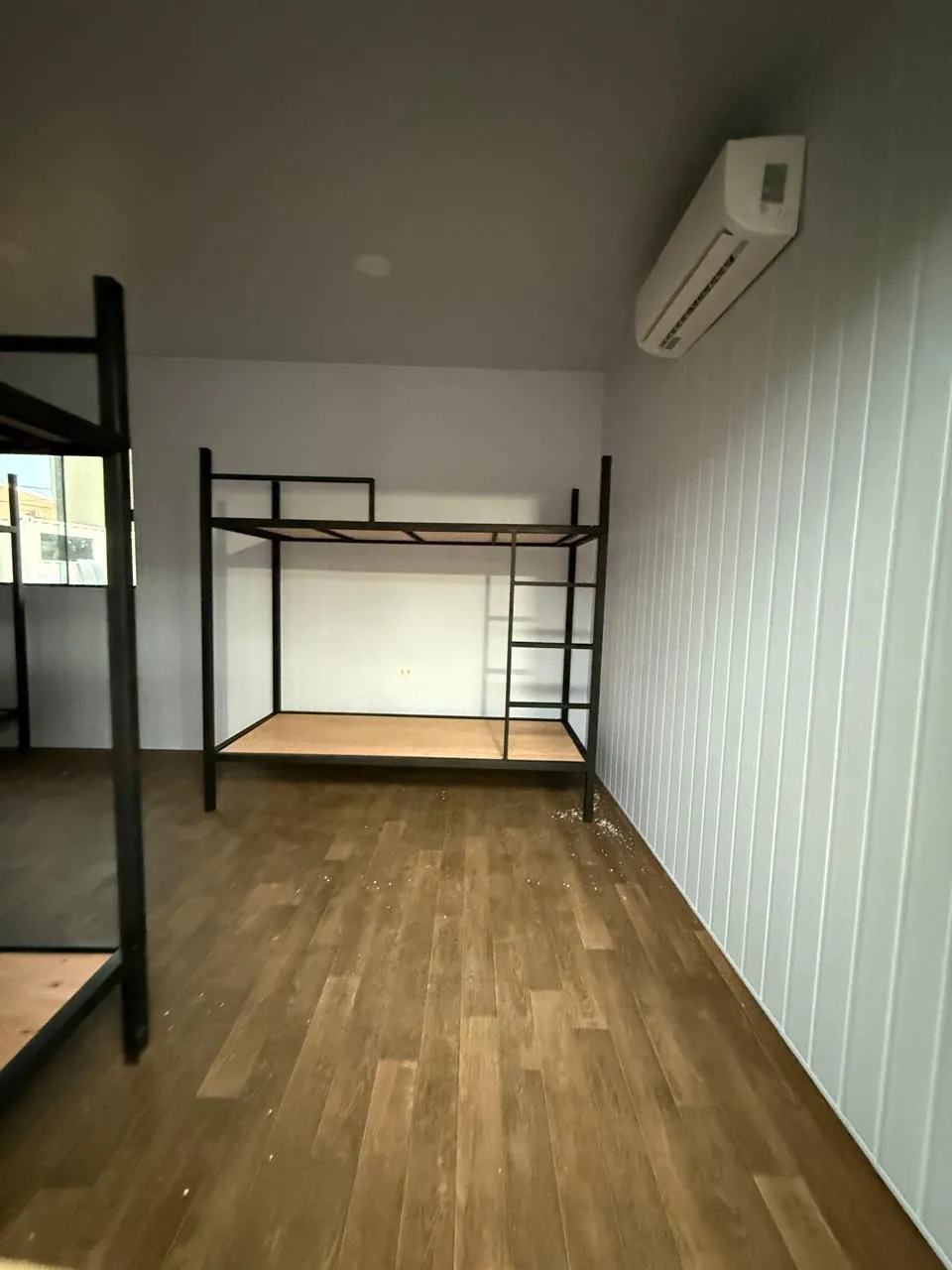 Dormitorio con litera, aire acondicionado split y revestimiento PVC acanalado