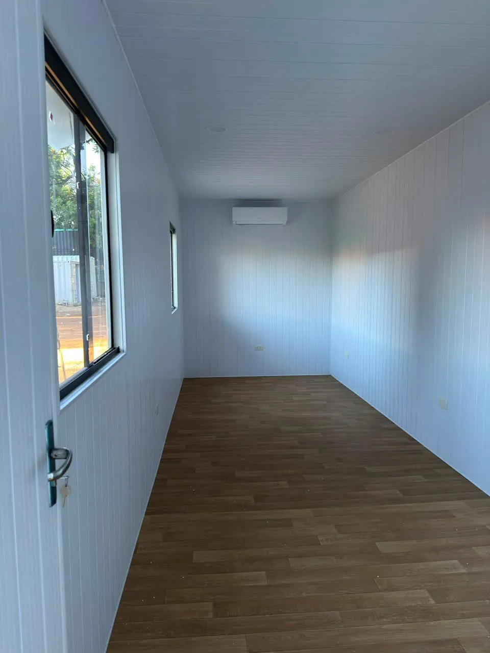 Oficina interior vacía con aire acondicionado split, LED y revestimiento PVC blanco