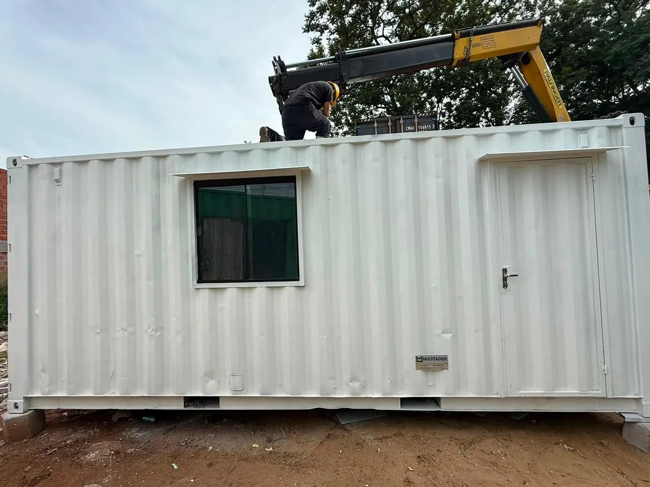 Oficina de obra 20 pies siendo instalada con grúa propia de Multitainer