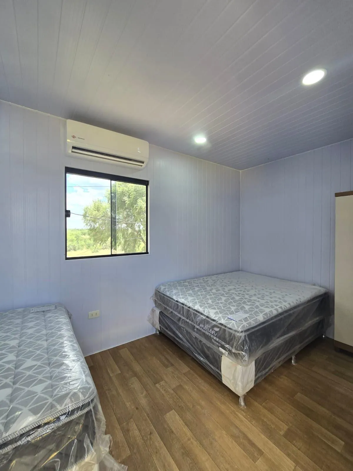 Dormitorio del puesto de control con camas nuevas embaladas y aire acondicionado