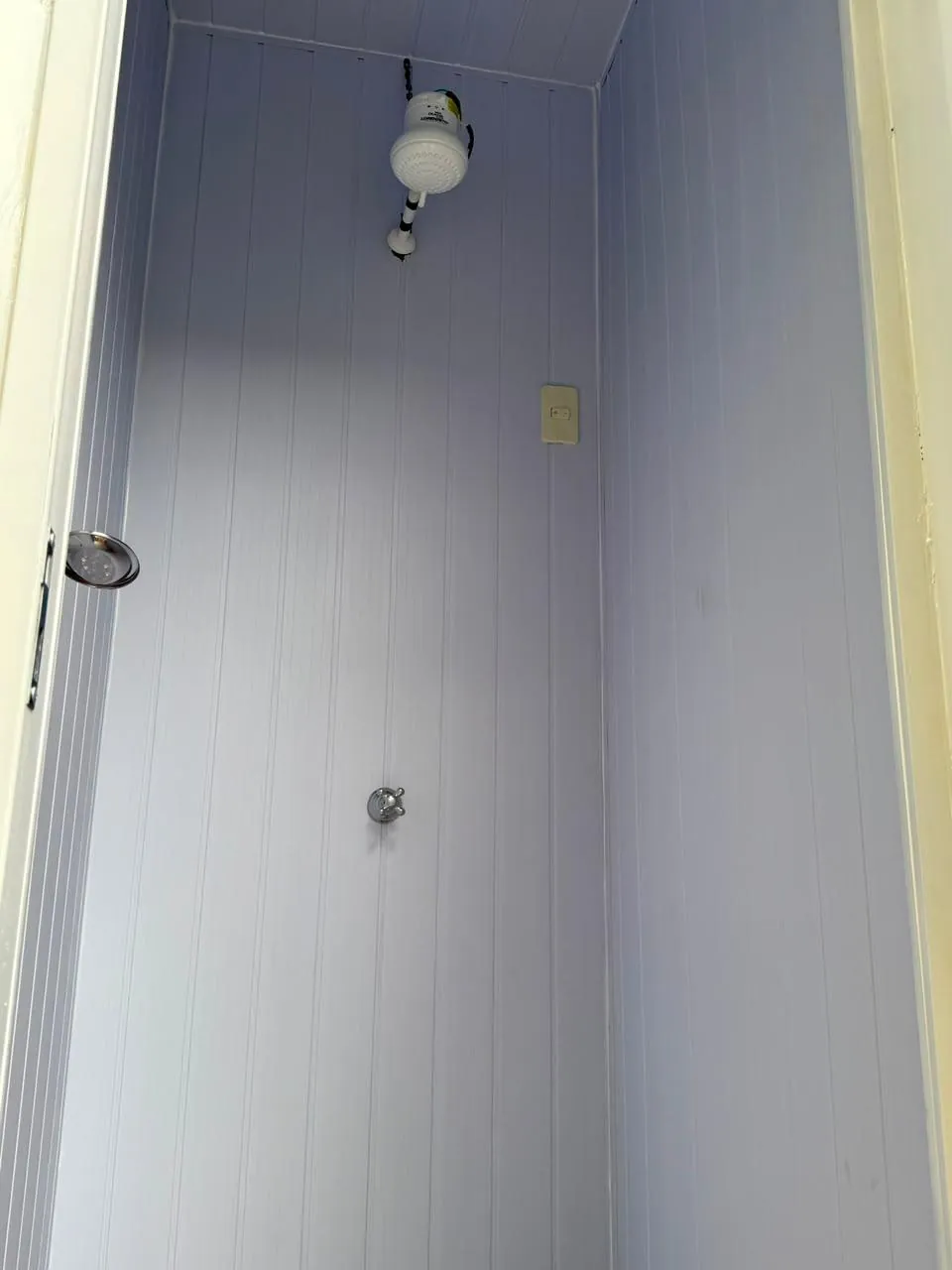 Interior de una ducha individual con revestimiento de paneles PVC
