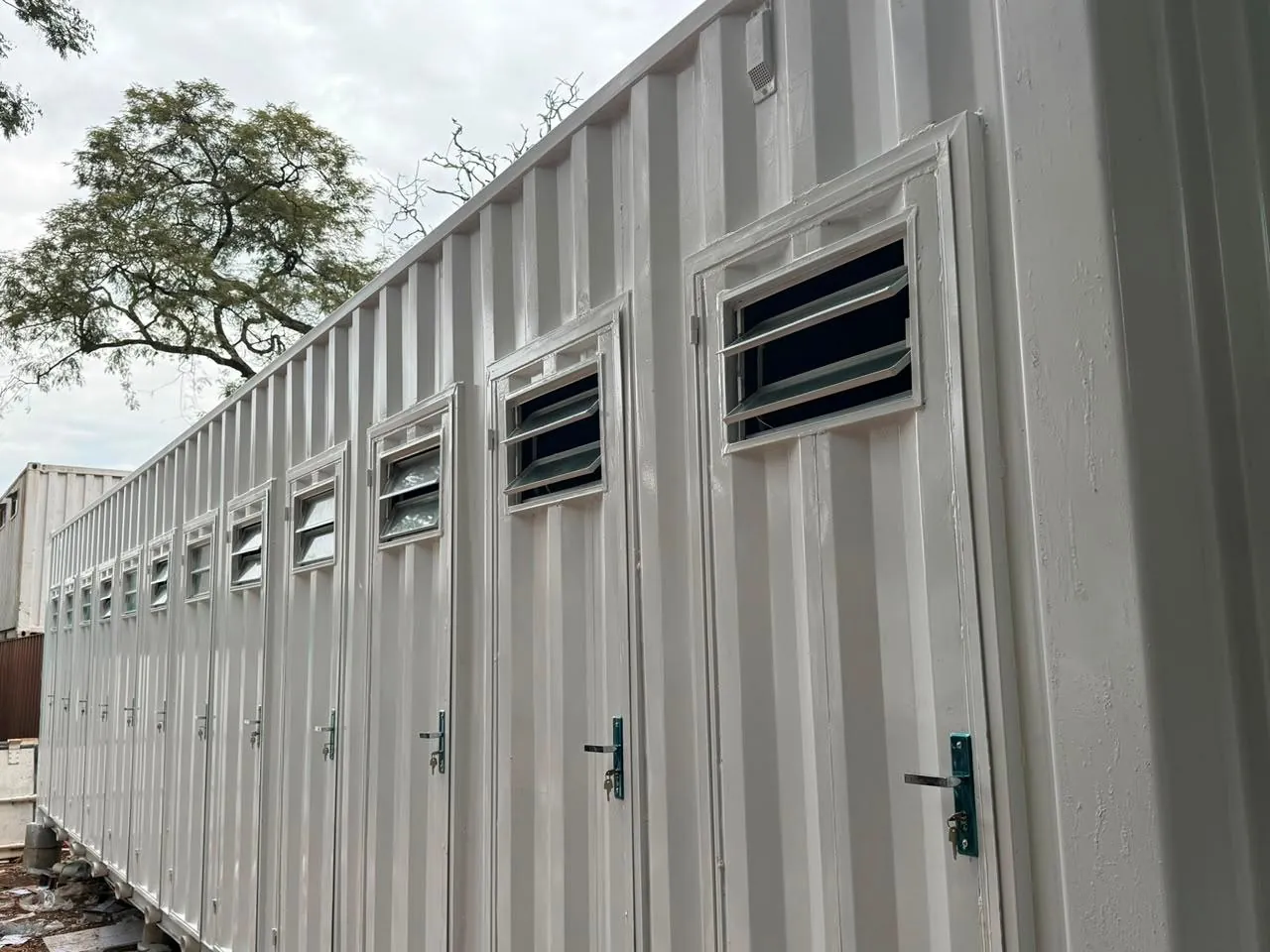 Vista lateral completa del módulo sanitario de 40 pies con puertas individuales