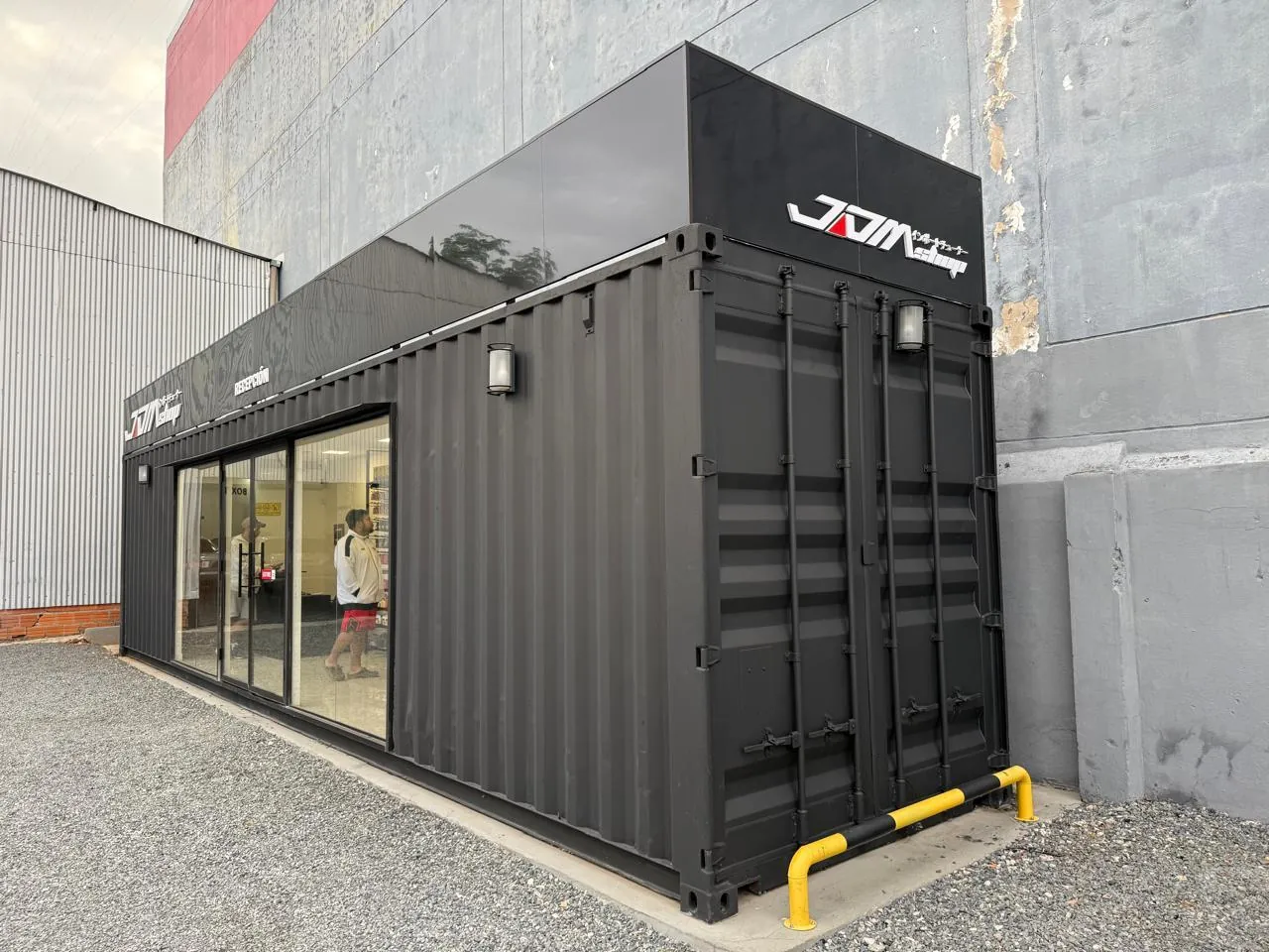 Extremo del showroom contenedor mostrando las puertas originales de container y sus herrajes