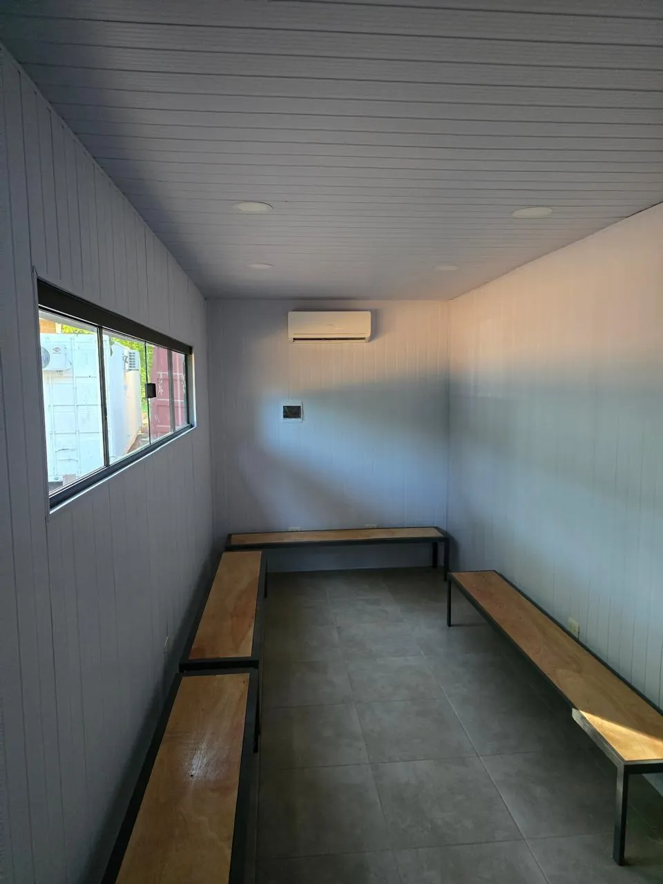 Interior del vestuario con aire acondicionado split y rejilla de ventilación