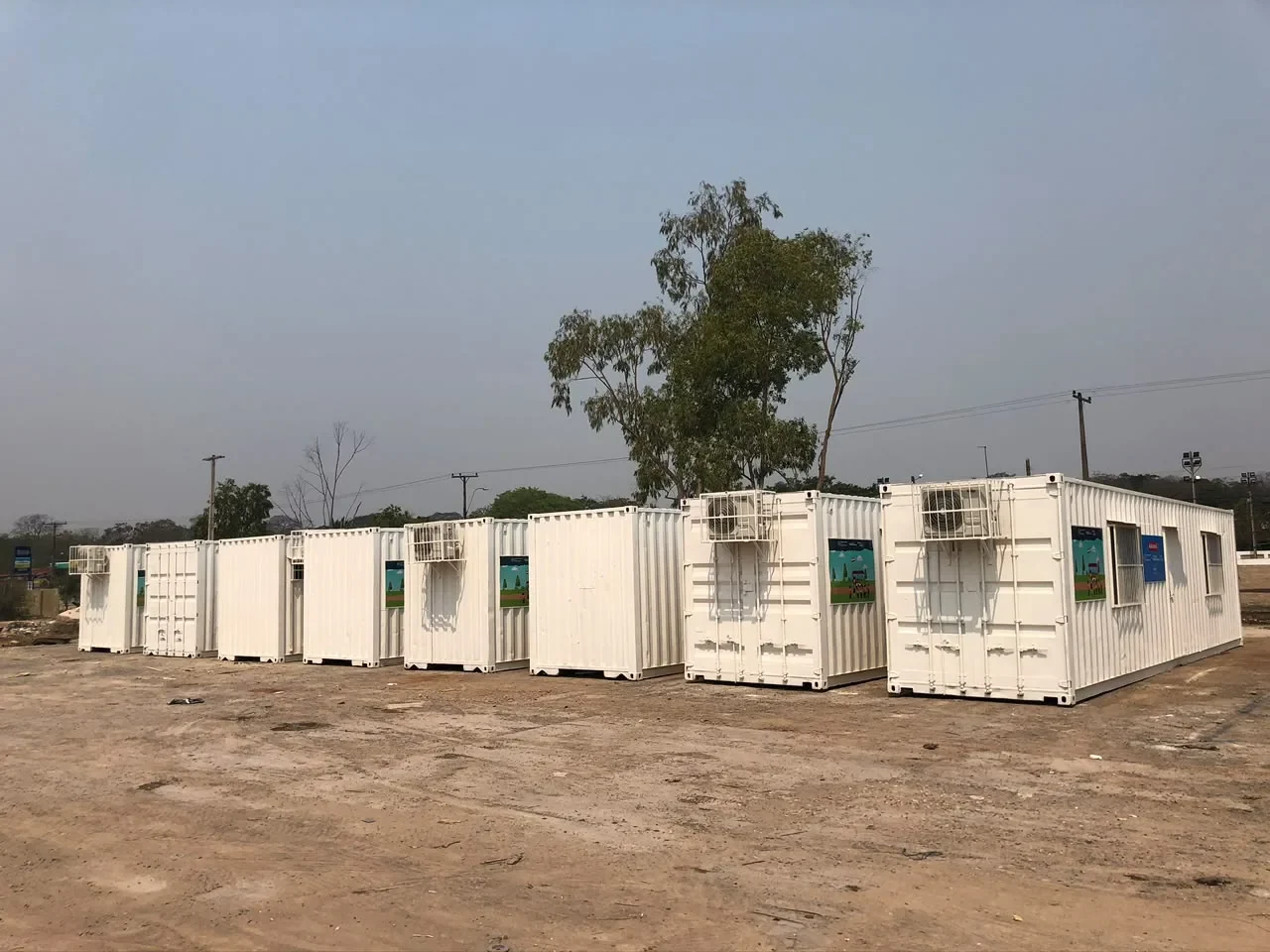 Hilera de módulos de contenedor blancos instalados en un predio institucional