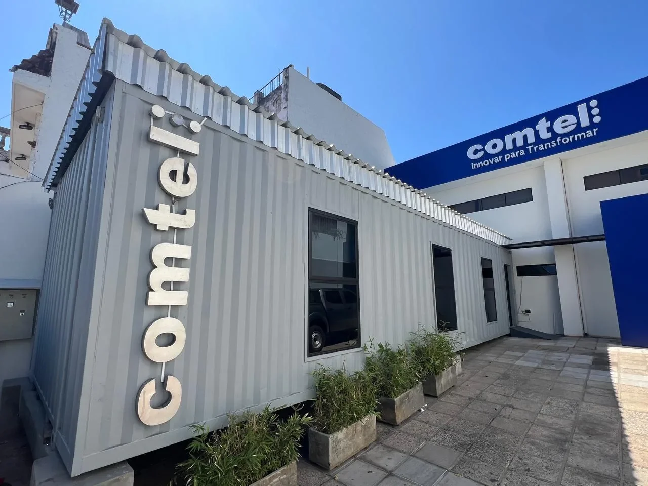 Oficina en contenedor con la marca Comtel a la calle