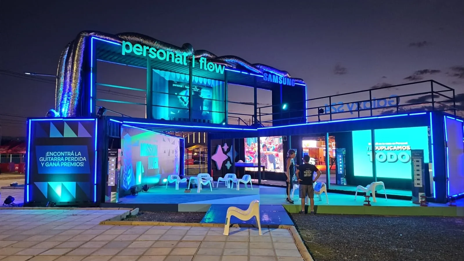 Stand de contenedor de dos plantas con iluminación LED en un evento nocturno